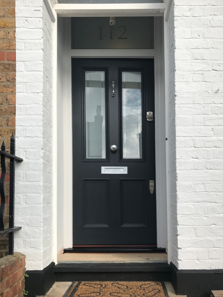 Victorian front door and door frame with etched glass panels and chrome door furniture.