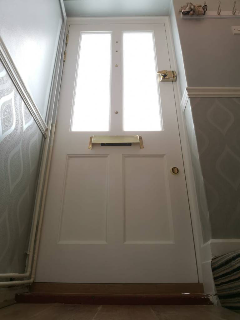 Victorian front door and door frame with etched glass panels, brass door furniture and Era locks. 