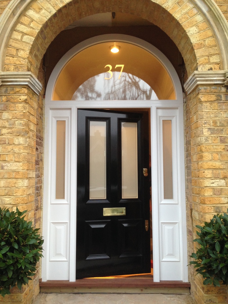 Solid and impressive-looking Victorian front door with four inlaid panels and polished brass door furniture. 