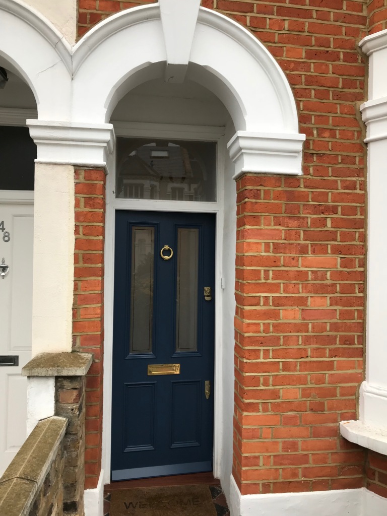 The intricate glazing and blue colour palette of this Victorian front door harmonize seamlessly with the overall aesthetic of the building.