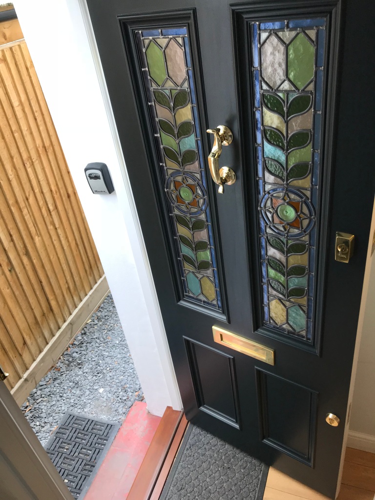This grand Edwardian door has two moulded panels and two stained glass panels featuring a flowers design. 