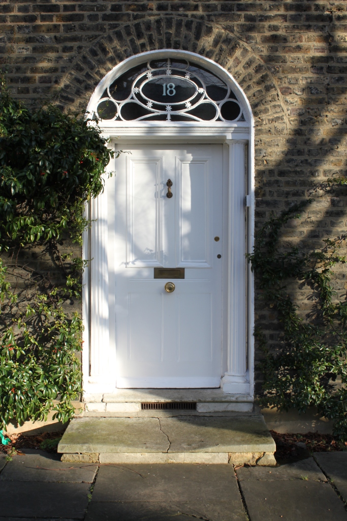 Edwardian front door with decorative stained glass panels, pure white finish and brass door furniture. 