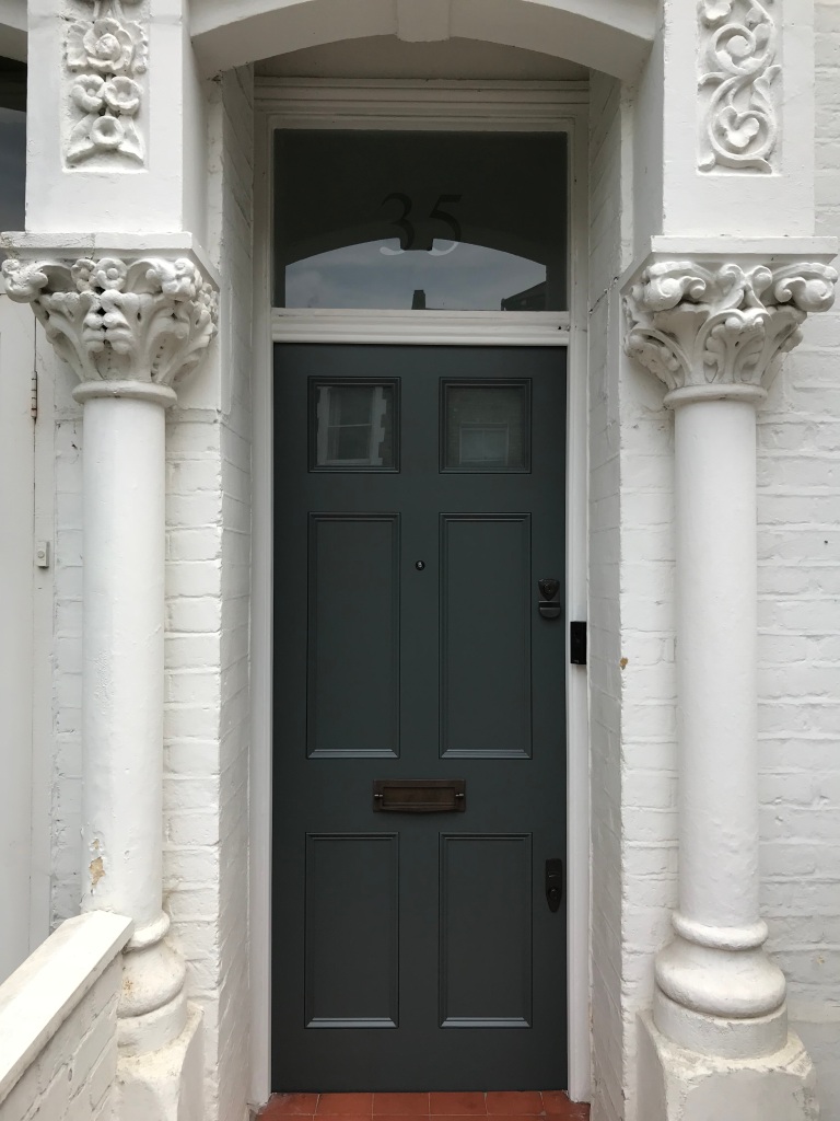 An exquisite Edwardian front door, painted in our exclusive colour, featuring sandblasted glass panelling and bronze door furniture. 